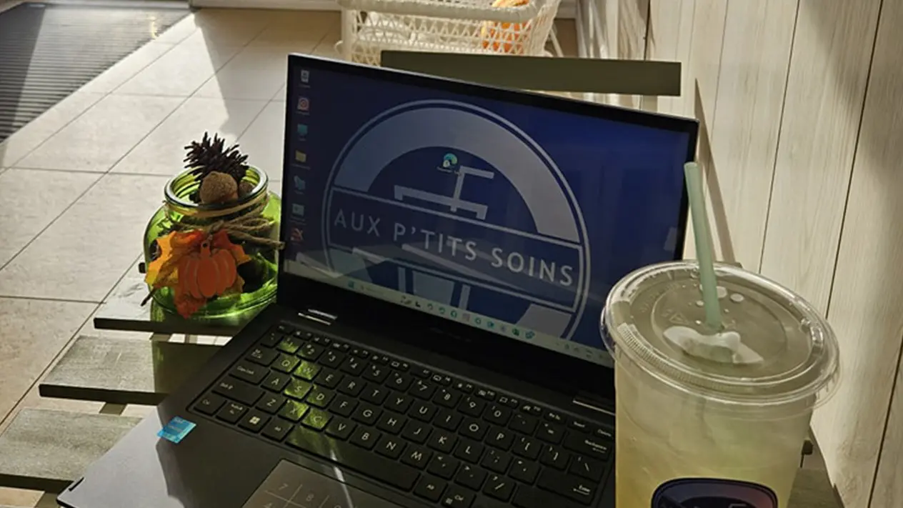 Ordinateur portable sur une table avec boisson, ambiance café (service bien-être/nutrition)